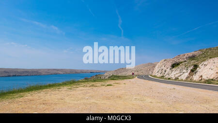 Eine kurvenreiche Straße entlang dem Meer auf der felsigen Insel Pag, Kroatien. Stockfoto