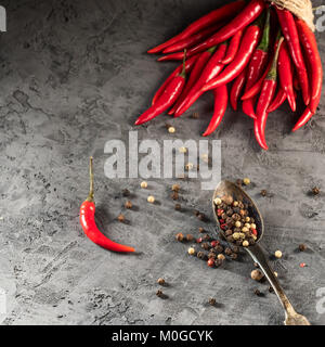 Red Hot Chili Pfeffer Paprika in und Paprika samen Kugel auf steinernen Tisch Zutat für mexikanische Küche, trendige Bild in minimalen rustikalen Stil gehaltenen Flach Top View Stockfoto