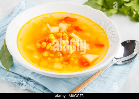 Gesunde hellen Gemüse mais Suppe in eine weiße Platte mit knusprigem Brot. Vegan Gesunde Ernährung Konzept. Stockfoto