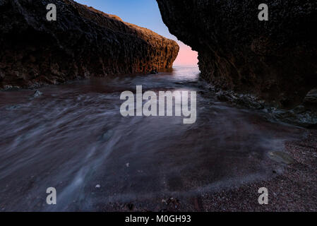 Tide auf Klippe Küste von hormuz Insel, Minuten nach Sonnenuntergang. Stockfoto