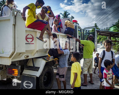 Camalig, Albay, Philippinen. 22 Jan, 2018. Menschen, die an den Hängen des Mayon Vulkan live aus der Regierung Lkw nach Ihrer Ankunft bei einer Evakuierung Center erhalten. Es gab eine Reihe von Eruptionen auf der Mayon Vulkan in der Nähe von Legazpi Montag. Die Eruptionen begann Sonntag Nacht und weiter durch den Tag. Um ca. 12.00 Uhr den Vulkan gesendet eine Wolke aus Asche und Rauch hoch über Camalig, die größte Gemeinde in der Nähe des Vulkans. Credit: ZUMA Press, Inc./Alamy leben Nachrichten Stockfoto