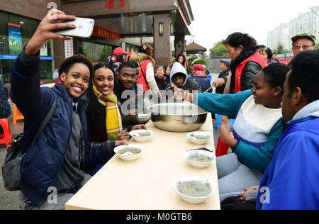 (180122) - ZHENJIANG, Jan. 22, 2018 (Xinhua) - Ausländische Studenten studieren in Jiangsu University, aus Pakistan, Jamaika und Äthiopien sind, selfies mit Laba Brei in Zhenjiang, im Osten der chinesischen Provinz Jiangsu, Jan. 22, 2018. Die Laba Festival, einer traditionellen chinesischen Festival am achten Tag des zwölften Mondmonats, fiel am 31.01.24 in diesem Jahr. Es ist üblich, an diesem Tag ein spezielles Laba Porridge, in der Regel mit mindestens acht Zutaten zu essen, die Gebete der Menschen für die Ernte. (Xinhua / Shi Yucheng) (Dhf) Stockfoto