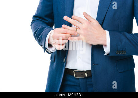 Teilansicht der Bräutigam trägt Hochzeit Ring isoliert auf weißem Stockfoto