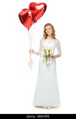 Schöne Braut im Brautkleid mit herzförmigen Luftballons und wedding bouquet isoliert auf weißem Stockfoto