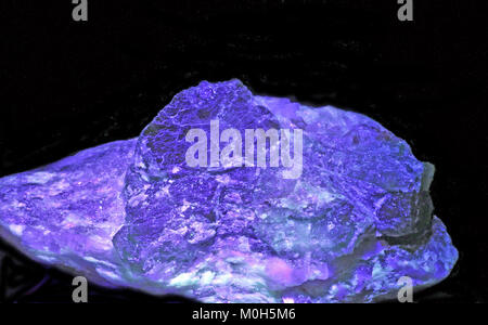 Das Foto zeigt eine smaragdgrüne beryl-on-Matrix aus Panjshir, Afghanistan, beleuchtet unter ultraviolettem Licht und enthüllt seine natürliche Kristallstruktur. Stockfoto