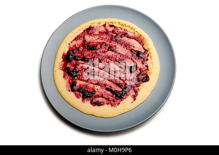 Pfannkuchen auf blaue Platte mit roten Früchten Marmelade isoliert auf Weiss. Freistellungspfad Stockfoto