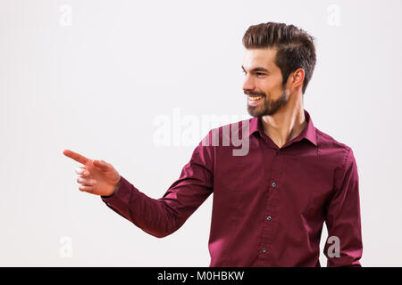 Studio shot Portrait von junge Unternehmer, die an ihrem Text oder Produkt zeigt. Stockfoto