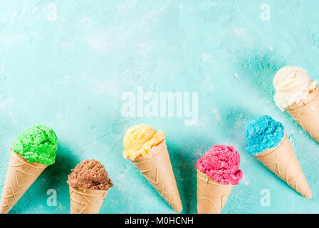 Auswahl von verschiedenen hellen bunten Eis in Eistüten - Schoko Vanille Erdbeere Heidelbeere Pistazie orange, hellblau Sunny b Stockfoto