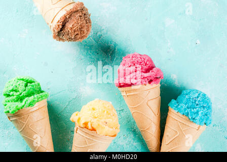 Auswahl von verschiedenen hellen bunten Eis in Eistüten - Schoko Vanille Erdbeere Heidelbeere Pistazie orange, hellblau Sunny b Stockfoto