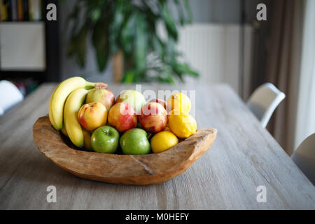 Holz- Obstkorb am Tisch im Wohnzimmer. Stockfoto