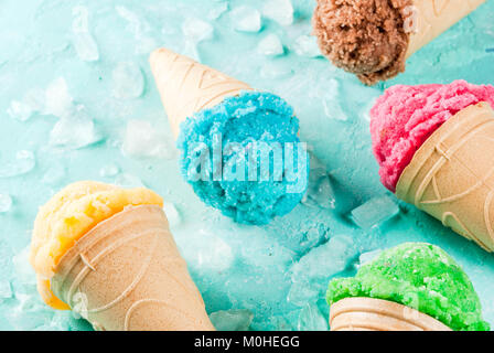 Auswahl von verschiedenen hellen bunten Eis in Eistüten - Schoko Vanille Erdbeere Heidelbeere Pistazie orange, hellblau Sunny b Stockfoto