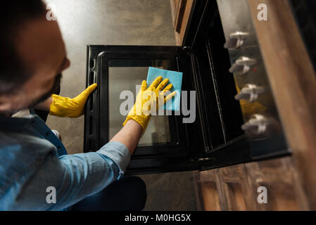 Professionelle männlichen Reiniger Pflege des Backofen Stockfoto