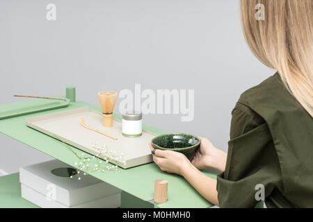 Mädchen mit Schüssel sitzt am Tisch Stockfoto