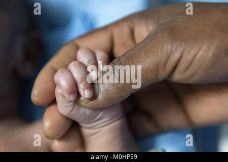 Nahaufnahme des Vaters Hand mit einem neugeborenen Baby hand Stockfoto
