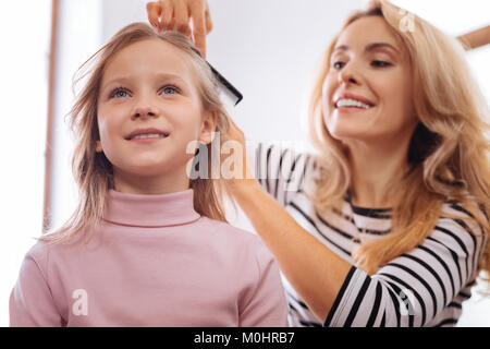 Liebevolle Mutter ihre Töchter Haar kämmen Stockfoto