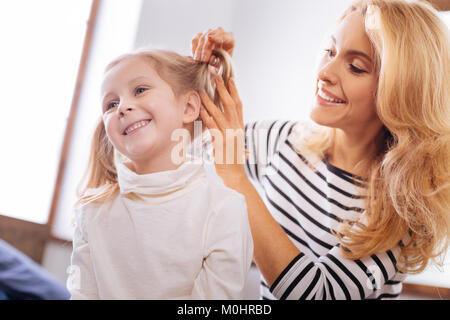 Fürsorgliche Mutter ihre Töchter Haar kämmen Stockfoto
