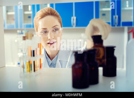 Schöne Wissenschaftlerin, die Flasche mit chemischen Flüssigkeit Stockfoto