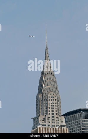 Die Spitze des Chrysler Building mit einem Jet fliegen Overhead, East Side von Manhattan in der Turtle Bay Area an der Kreuzung der 42. Straße ein Stockfoto