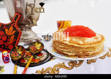 Pfannkuchen mit roter Kaviar auf dem Hintergrund der Samowar und Holz- Gerichte in Khokhloma Stil Stockfoto