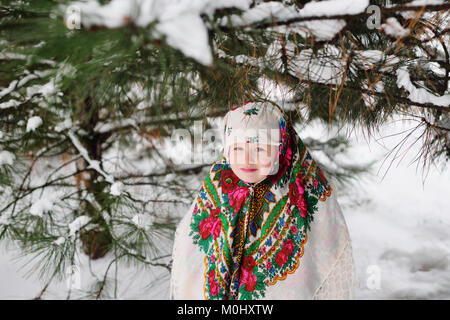 Porträt eines Kindes Mädchen mit Kopftuch in der Urs Stil auf dem Hintergrund von Schnee und Wald Stockfoto