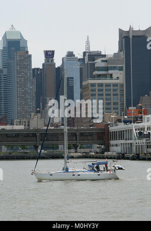 Drei Männer auf einer kleinen Yacht vor dem Gebäude auf dem Hudson River, Midtown West Manhattan, New York City, New York State, USA. Stockfoto