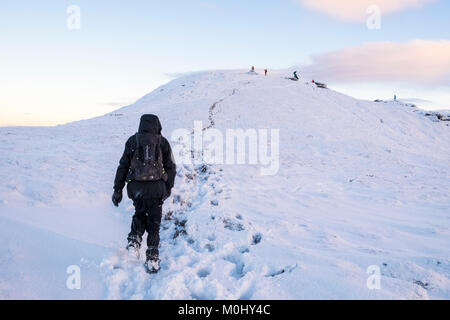 Winter wandern. Ein Wanderer Wandern im Schnee auf einem Hügel in der Landschaft, Grindslow Knoll, Kinder Scout, Derbyshire, Peak District, England, Großbritannien Stockfoto