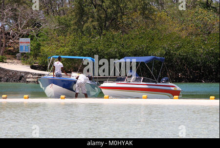 Vier Männer durch zwei Strände Tour Boote auf der Ile aux Cerfs, einer privaten Insel in der Nähe der Ostküste der Republik Mauritius in der flacq Distri Stockfoto