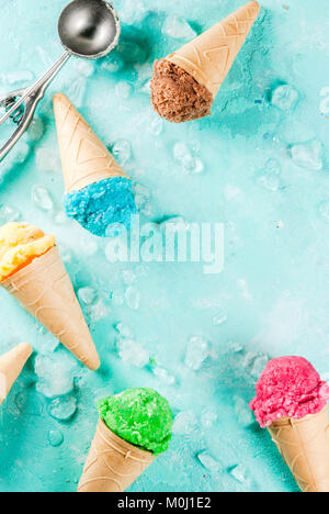 Auswahl von verschiedenen hellen bunten Eis in Eistüten - Schoko Vanille Erdbeere Heidelbeere Pistazie orange, hellblau Sunny b Stockfoto
