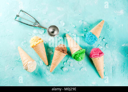 Auswahl von verschiedenen hellen bunten Eis in Eistüten - Schoko Vanille Erdbeere Heidelbeere Pistazie orange, hellblau Sunny b Stockfoto