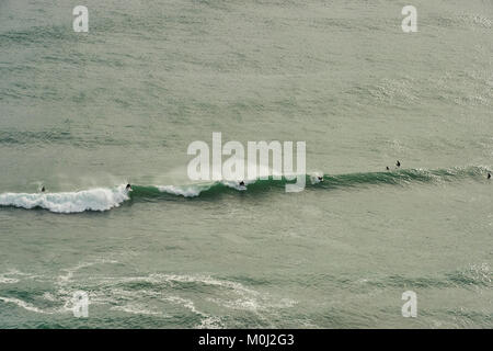 Surfer Catch a wave bei Piha Beach, North Island, Neuseeland Stockfoto