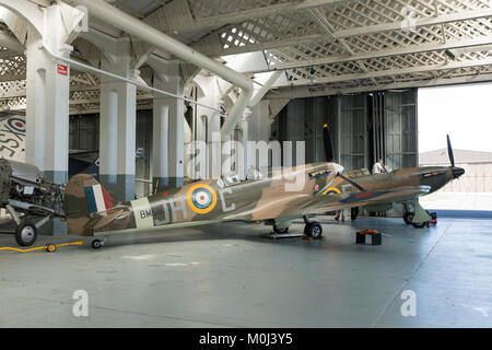 Supermarine Spitfire, mit einer Hawker Hurricane hinter, in einem Flugzeughangar am 23. September 2017 in Duxford Cambridgeshire, Großbritannien Stockfoto