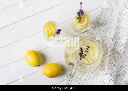 Blick von oben auf die Citrus Limonade mit Lavendelblüten und Zitrone Stücke in Gläser und Glas Stockfoto