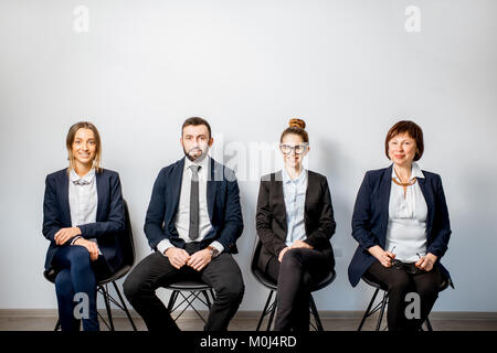 Business-Leute sitzen in einer Reihe Stockfoto