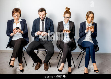 Business-Leute sitzen in einer Reihe Stockfoto