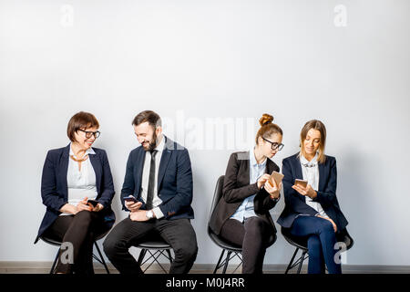 Business-Leute sitzen in einer Reihe Stockfoto