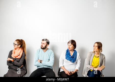 Menschen in einer zwanglosen Sitzen in einer Reihe Stockfoto