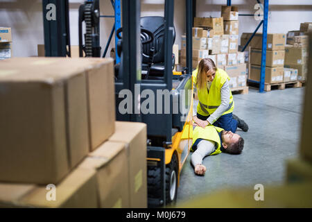 Das lagerpersonal nach einem Unfall in einem Lager. Stockfoto