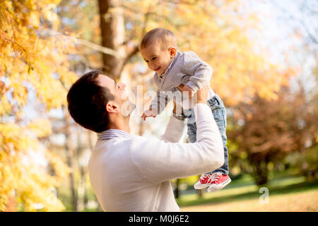 Junger Vater und Baby boy spielen im Herbst Park an einem sonnigen Tag Stockfoto