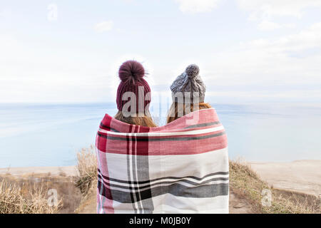 Zwei Freunde in eine Decke auf Täuschungen über den Lake Ontario suchen gewickelt; Scarborough, Ontario, Kanada Stockfoto