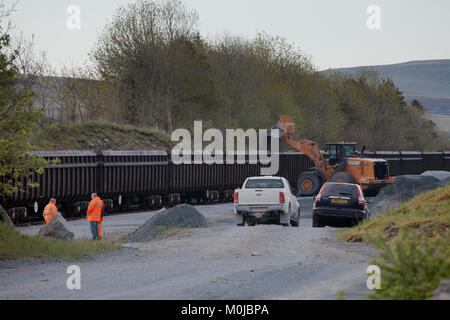 DB Cargo Aggregate Zug mit gritstone in der abstellgleise Geladen neben Ribblehead Station (der alte Steinbruch Ribblehead) Stockfoto