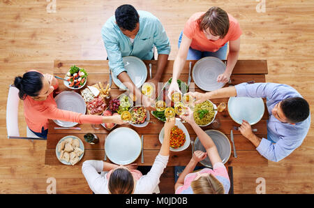 Menschen mit Abendessen und klirren Weingläser Stockfoto