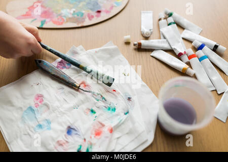 Künstler hand mit Pinsel, Papier und Farbe Rohre Stockfoto
