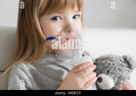 Kleine Mädchen, die Inhalation mit Zerstäuber zu Hause. Kind Asthma Inhalator einatmen Vernebler Dampf krank Husten Konzept Horizontal Stockfoto