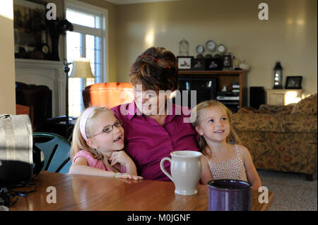 Eine Großmutter mit Kuscheln und eine Diskussion mit ihren Enkelinnen Stockfoto