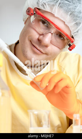 Junge Mikrobiologen in schützende Arbeitskleidung lächeln in die Kamera Stockfoto