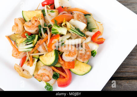 Garnelen mit Gemüse braten über Holz Hintergrund rühren Stockfoto