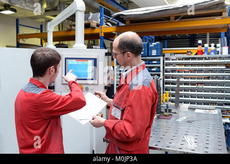 Auszubildende und Ausbilder in einem metallverarbeitenden Unternehmen - Ausbildung im Handel Stockfoto