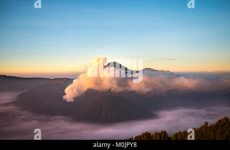 Blick auf Vulkane bei Sonnenaufgang, Rauchender Vulkan Gunung Bromo, Batok, Kursi, Gunung Semeru, Bromo-Tengger-Semeru National Park Stockfoto