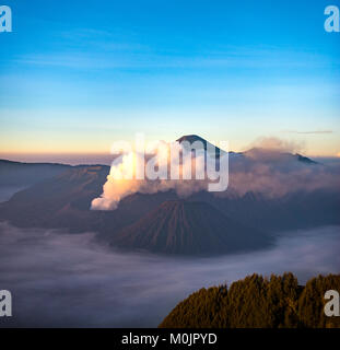 Blick auf Vulkane bei Sonnenaufgang, Rauchender Vulkan Gunung Bromo, Batok, Kursi, Gunung Semeru, Bromo-Tengger-Semeru National Park Stockfoto