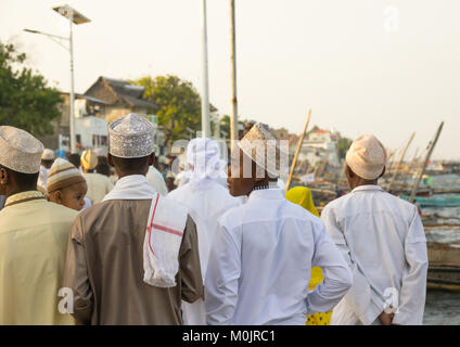 Männern, die mawlid Feiern auf dem Lamu Corniche durch den Sonnenuntergang, Lamu Island, Kenia Stockfoto